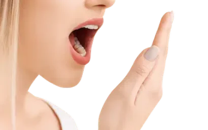 Mujer comprobando su aliento, síntoma habitual de halitosis o mal aliento dental
