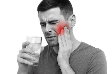 Hombre con sensibilidad dental provocada por el desgaste de dientes causado por bruxismo