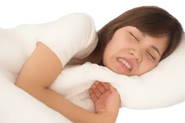 Mujer apretando los dientes durante el sueño por bruxismo nocturno