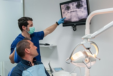 Dr. Jorge Ferrer valoración dental con paciente y explicación de radiografía