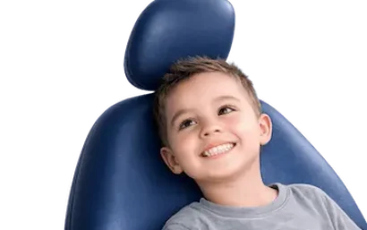 Niño sonriente en sillón dental durante tratamiento infantil en clínica dental de Murcia