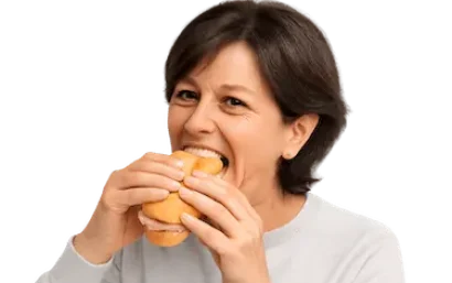 Mujer comiendo con comodidad gracias a una prótesis dental sin implantes en Murcia