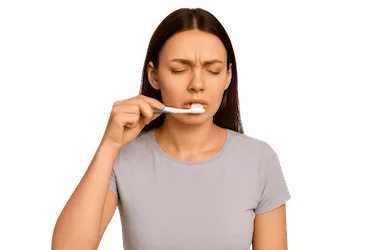 Mujer cepillándose los dientes con suavidad durante una urgencia dental en Madrid