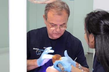 Dr. Ferrer realizando un tratamiento dental con su equipo en la clínica de Chamberí, Madrid
