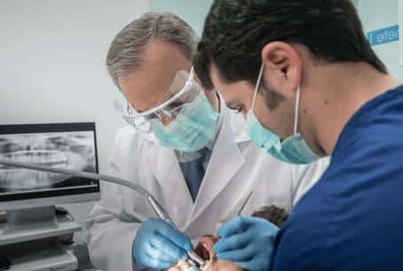 doctores Francisco y Jorge Ferrer atendiendo a un paciente durante una consulta en la clínica dental