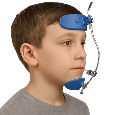 Niño usando una máscara facial para adelantar el maxilar superior en ortopedia infantil