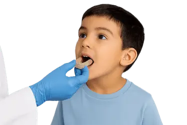 Dentista examinando la boca de un niño para valorar un tratamiento de ortodoncia infantil