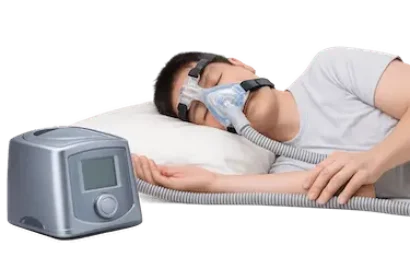 Paciente durmiendo con máquina CPAP para tratar la apnea del sueño y mejorar la respiración nocturna